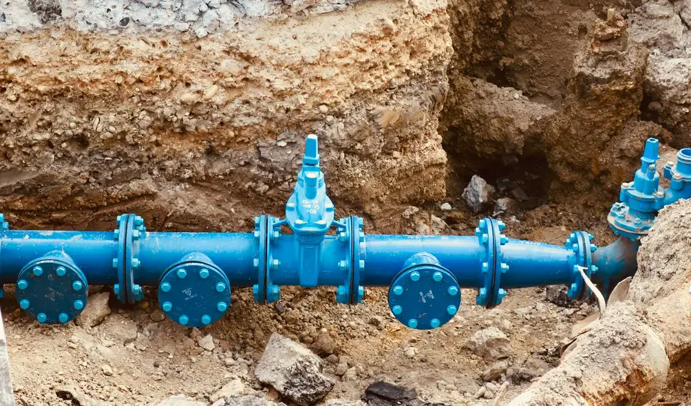 bir yığın toprağın üstünde yatan mavi boru